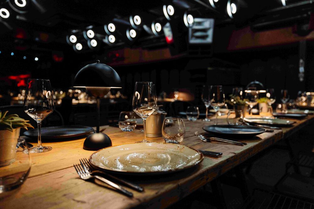 Gedeckte Tische für ein elegantes Corporate Dinner im Unterdeck von Fridas Pier in Stuttgart.