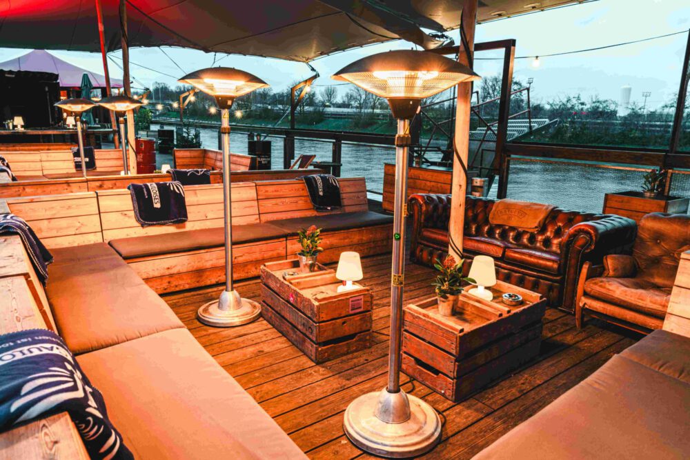 Gemütlich beleuchtetes Oberdeck von Fridas Pier mit einladender Atmosphäre, geeignet für Sommer‑ und Winterevents.