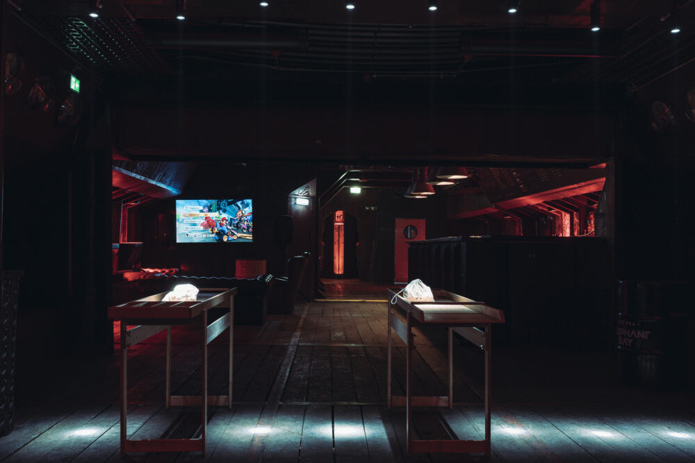 Unterdeck im Winterhafen von Fridas Pier mit Spiele‑Station und Mario‑Kart‑Setup für Firmen‑Weihnachtsfeiern und Winterevents.