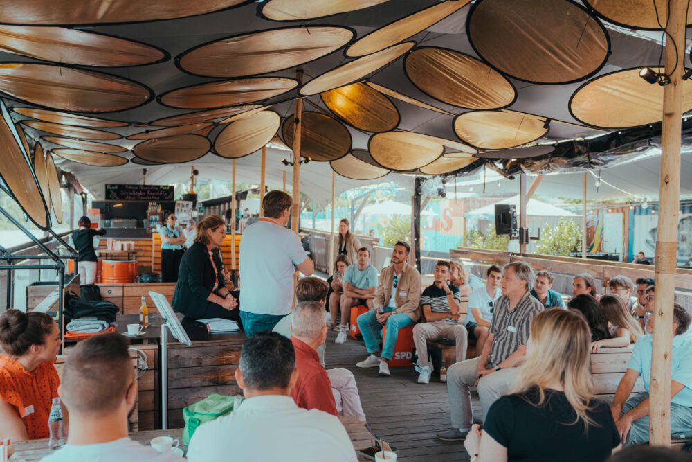 Oberdeck von Fridas Pier als Pausenbereich mit Sonnensegel, Sitzgruppen und Blick auf das Neckarufer