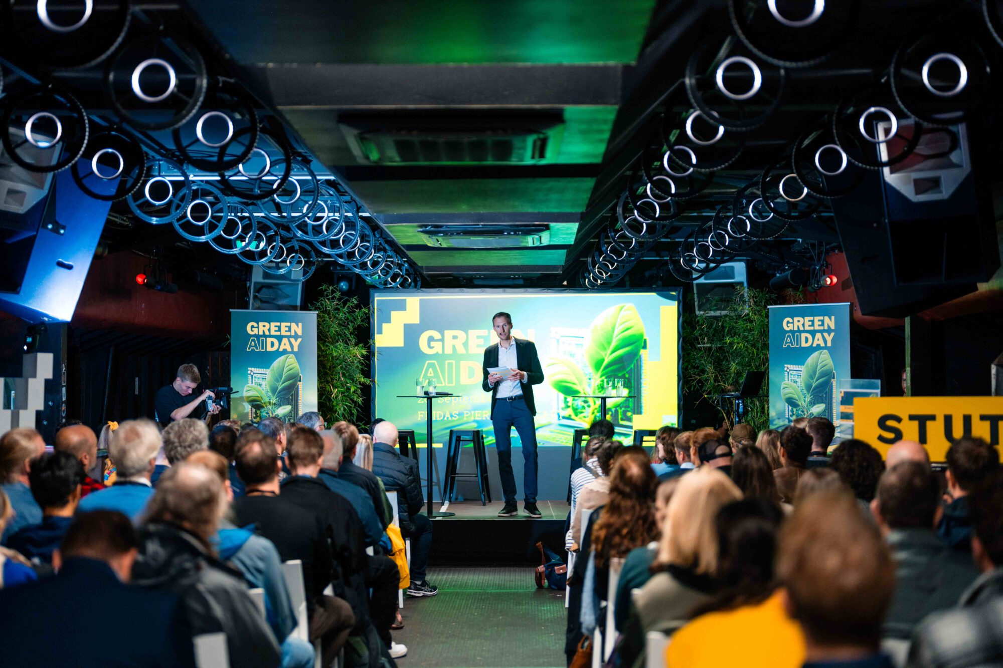 Seminarraum im Unterdeck von Fridas Pier in Stuttgart mit Bühne, Leinwand und Reihenbestuhlung im Industriecharme direkt am Neckar.